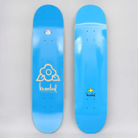 Krooked Ikons 2 PP Blue skateboard deck: Plain bright blue deck shown top and underside. The bottom carries a tan outline flower with leaves above the handwritten krooked skateboarding logo. The top has a small yellow Krooked bird logo and logo.