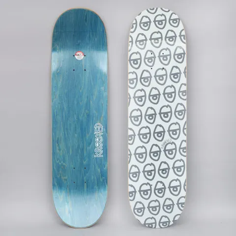 Krooked Pewpils Grey skateboard deck: The graphic is a repeating all-over pattern of grey cartoon eyes on a pale ground. A deck with blue wood-veneer underside is shown beside it.