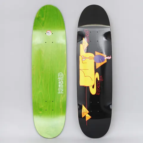 Krooked Cromer Sfinkgx Black skateboard deck: Black shaped deck with a yellow reclining sphinx-like figure, a small purple-bodied figure standing on it, and orange pyramids with a red line. Photo also shows the green-stained underside with Krooked logo.