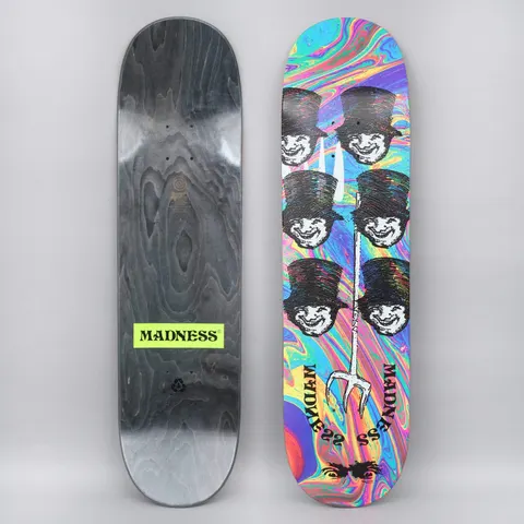 Madness Mayhem Popsicle skateboard deck: Six black top-hatted grinning faces in two columns, with a white trident through the middle, on a swirling rainbow oil-slick background. Madness lettering curved at the foot. Wood underside shown with a green logo.