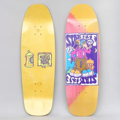New Deal Siamese Double Kick Neon skateboard deck: Old-school shaped deck with a pink stained top and a purple-bordered panel showing two-headed cartoon Siamese twin figure in pink jacket, chains and big boots by a hydrant, with speech bubbles. Yellow underside with a spray can.