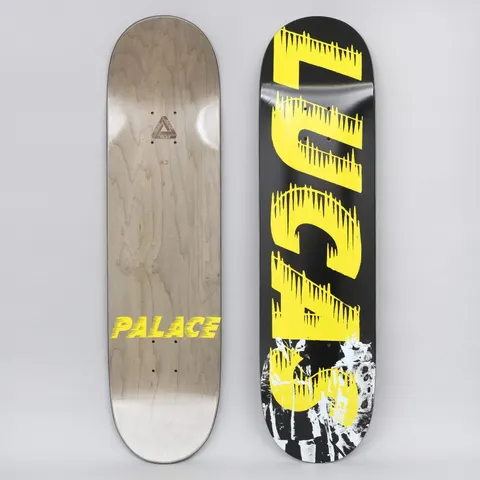 Palace Lucas S21 skateboard deck: Black deck with large yellow dripping, spiky lettering reading 'LUCAS' running down it, over a distressed black and white photographic image at the bottom. The underside has a yellow Palace logo.