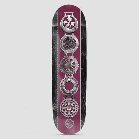 Passport Brasses Pro Series Matlok skateboard deck: A vertical column of five ornate silver horse brasses on a burgundy stripe, between black stained wood-grain edges. The Pass~Port logo and rider name sit at the tail.