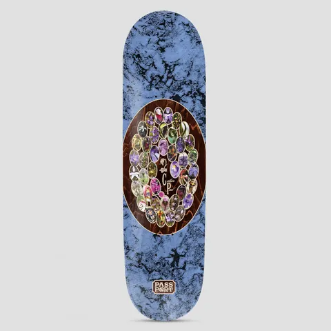 Passport Callum Yearbook Series skateboard deck: A brown wood-grain oval contains a ring of small oval photographs of purple, yellow and green orchids around initials. The surround is marbled blue, and a small Passport logo sits near the tail.