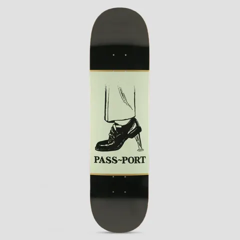 Passport Shoe Series Gumshoe skateboard deck: A black line drawing of a trouser leg and a lace-up shoe with a heel stuck in gum or a drain grate, on a pale green panel with 'Pass~Port' beneath, set on a black deck.