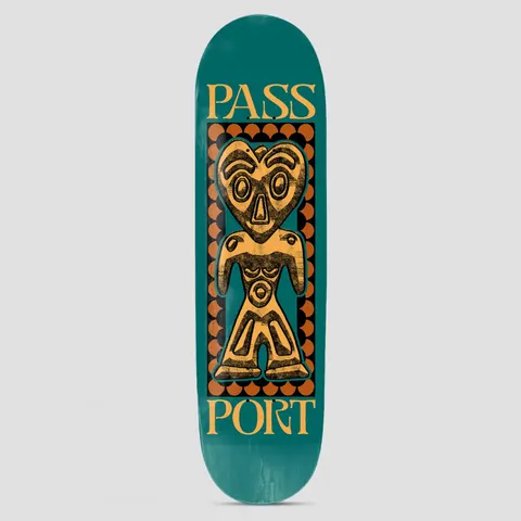 Passport Dogu Series Heart Head skateboard deck: A heart-headed clay figure in the style of an ancient Japanese dogu statue, in gold with black texture, framed by a scalloped orange border on a teal deck, with the word Passport split across the top and bottom.