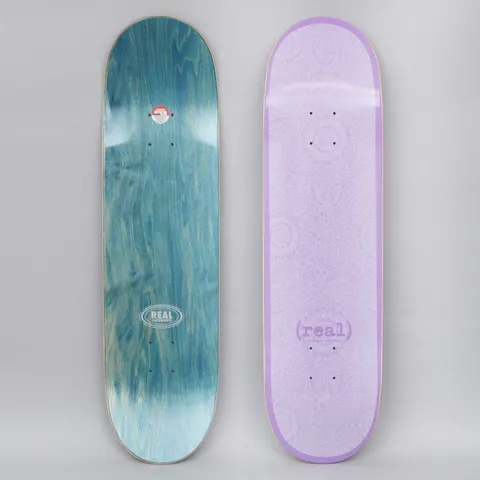 Real Flowers Renewal Purple skateboard deck: A tonal lilac deck with a faint all-over pattern of flowers and birds, a darker purple border and a small lowercase (real) logo with edition text near the tail. The underside is teal-stained wood with an oval Real logo.