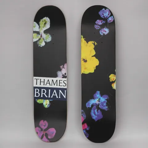 Thames MMXX Thames 7.75 Night Orchid 1 skateboard deck: Loose painted orchid-like flowers in purple, blue, yellow, pink and lime scattered across a black deck. One deck carries a white and navy THAMES BRIAN label across the middle.