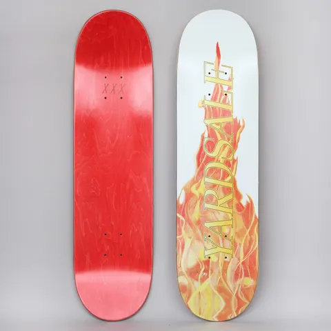 Yardsale Fuego White skateboard deck: Both sides shown. A photographic bonfire of orange, red and yellow flames rises up a white deck, with YARDSALE in gold serif capitals running vertically over it. The underside is red-stained with XXX near the top.