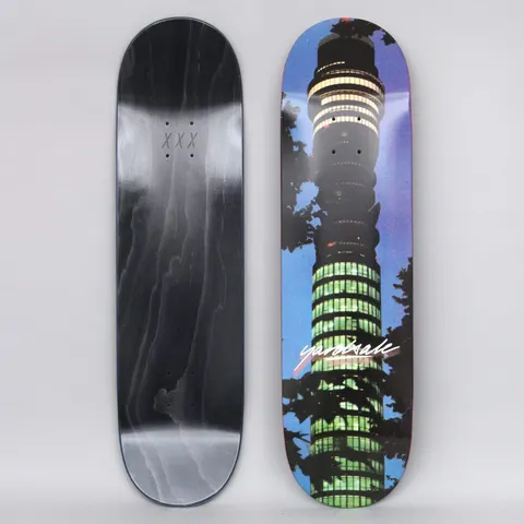 Yardsale BT Tower skateboard deck: Night-time photograph of the BT Tower in London, its lit windows glowing green and yellow, framed by dark tree branches against a blue-purple sky. A white script logo sits across the middle.