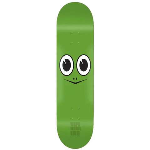 Toy Machine Turtle Face 7.75 skateboard deck: A plain green deck with a simple cartoon turtle face: two large round eyes and a small V-shaped mouth with nostrils. Faint Toy Machine lettering near the tail.