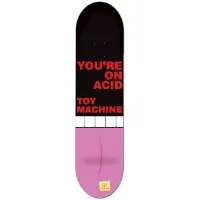 Toy Machine Acid skateboard deck: Bold red block capitals on a black upper half read 'You're on acid, Toy Machine', above a row of white blocks. The lower half is pink, like a giant pill or tongue, with a faint curved line and a small yellow logo at the tail.