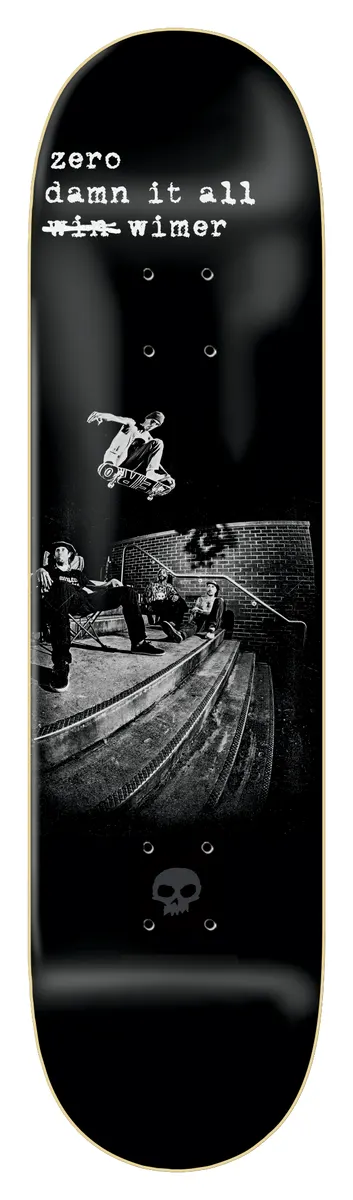 Zero Fs Flip - Wimer 8.25 skateboard deck: Black and white photograph of a skater frontside flipping down a set of steps beside a brick wall, with onlookers seated at left. Rider text at top has 'win' struck out; small grey Zero skull at the tail.