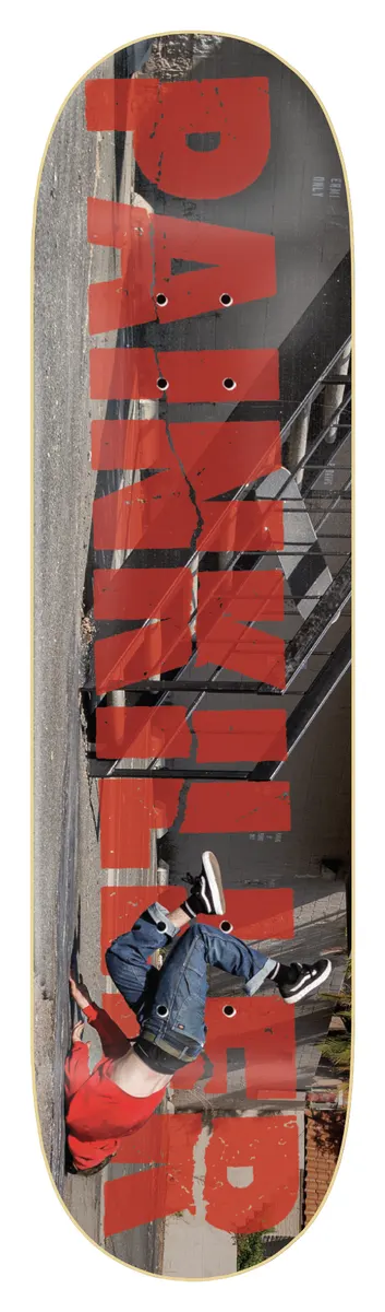 Zero Painkiller 8.375 skateboard deck: Large distressed red 'Painkiller' lettering running sideways over a photo of a skater falling backwards beside a staircase handrail, with the rider's legs in the air. Black border.