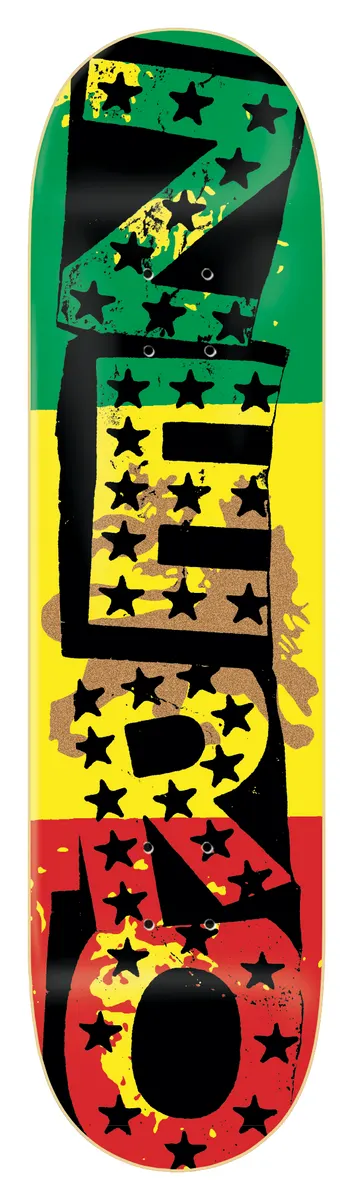 Zero Sandoval - Rasta Punk 8.25 skateboard deck: Large black Zero lettering with stencil-like blocks and black stars, over horizontal green, yellow and red stripes with a faded lion shape, on a black deck.