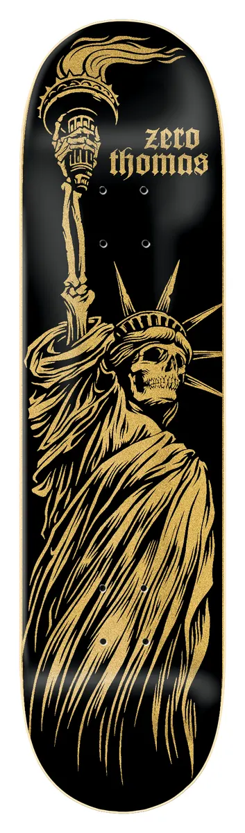 Zero Thomas - Liberty Or Death 8.25 skateboard deck: Black deck with a gold, engraving-style Statue of Liberty with a skull face and skeletal hand holding the torch. Zero Thomas in gold gothic lettering at the upper right.